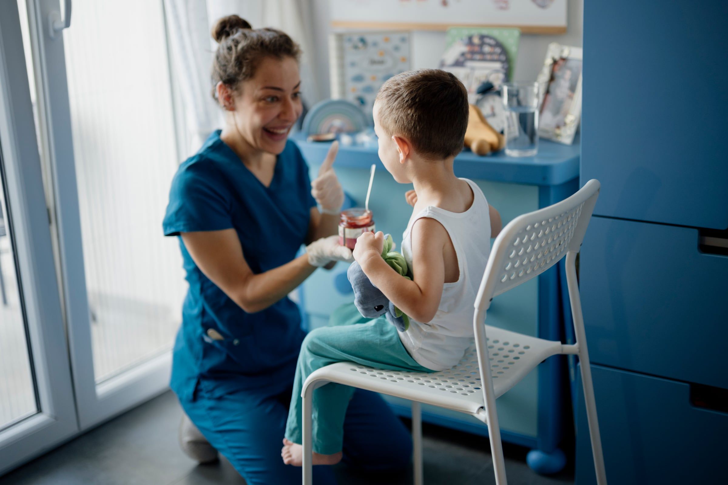 Dentista sonriente atendiendo a un niño en un consultorio luminoso
